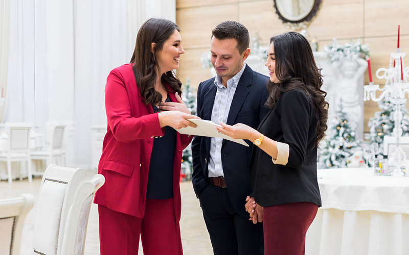 Cặp đôi đang xem xét và ký hợp đồng thuê váy cưới