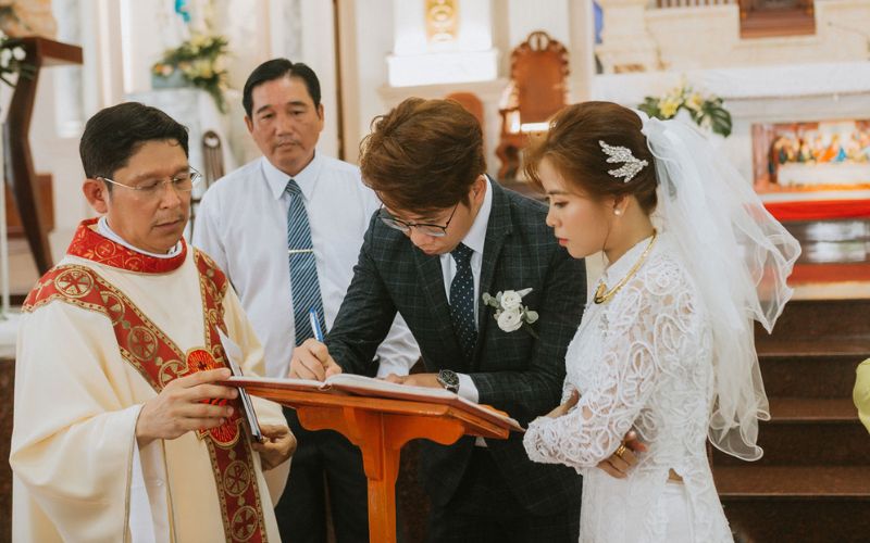 Cô dâu chú rể cùng nhau ký tên vào sổ hôn phối