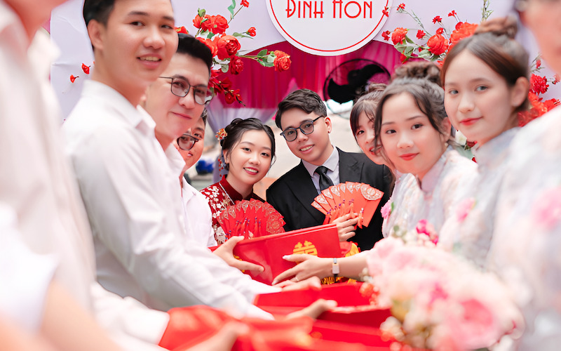 Đội bê tráp nam của nhà trai sẽ tiến vào, trao từng mâm quả lễ vật cho đội nhận tráp nữ của nhà gái trong không khí trang trọng, vui tươi